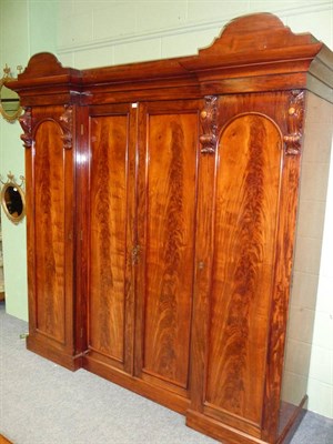 Lot 1283 - A Victorian Mahogany Four Door Wardrobe, of inverted breakfront form, the domed and moulded cornice