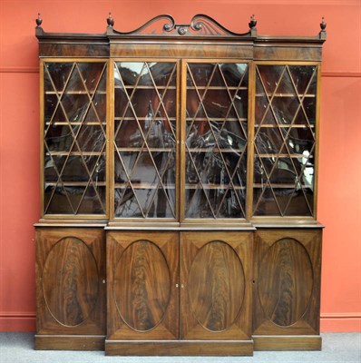 Lot 1328 - A George III Mahogany Four Door Breakfront Bookcase, the pierced swan-neck pediment with turned...