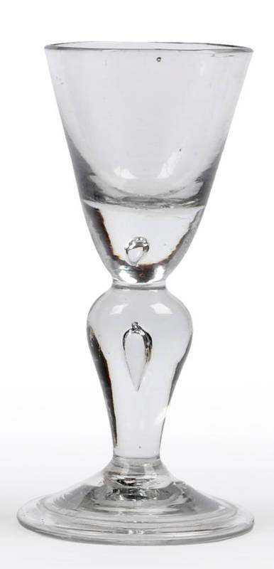 Lot 20 - A Heavy Baluster Wine Glass, circa 1710, the funnel bowl with solid base with tear, on a teared...