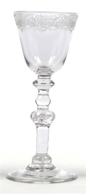 Lot 28 - A Wine Glass, circa 1730, the round funnel bowl engraved with baroque border, the stem with...