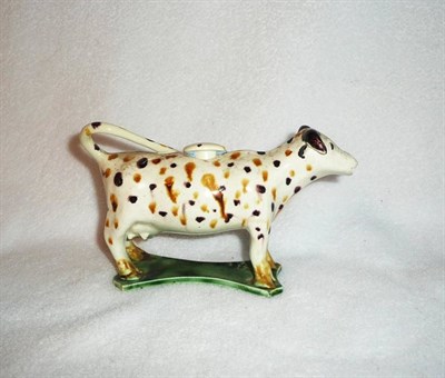 Lot 112 - An English Creamware Cow Creamer, circa 1800, naturalistically modelled standing on all fours...