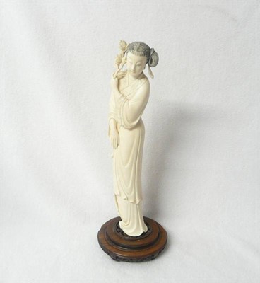 Lot 215 - A Chinese One Piece Carved Elephant Tusk Figure of a Maiden, circa 1930, her hair in a chignon,...