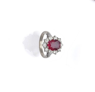 Lot 450 - A Ruby and Diamond Cluster Ring, the oval cut ruby within a border of round brilliant cut...