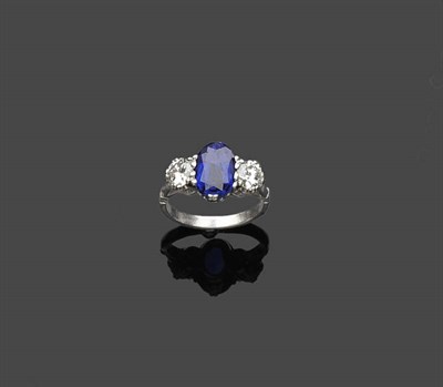 Lot 458 - A Sapphire and Diamond Three Stone Ring, the oval mixed cut sapphire flanked by a round...