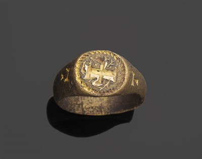 Lot 468 - A Medieval Ring, a cruciform symbol on the round table, within a rope border, and a letter T on...