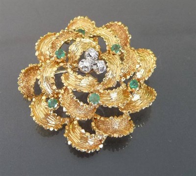 Lot 491 - A Diamond and Emerald Brooch, a central cluster of round brilliant cut diamonds set within textured