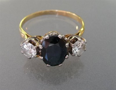 Lot 496 - A Sapphire and Diamond Three Stone Ring, the oval mixed cut sapphire flanked by a round...