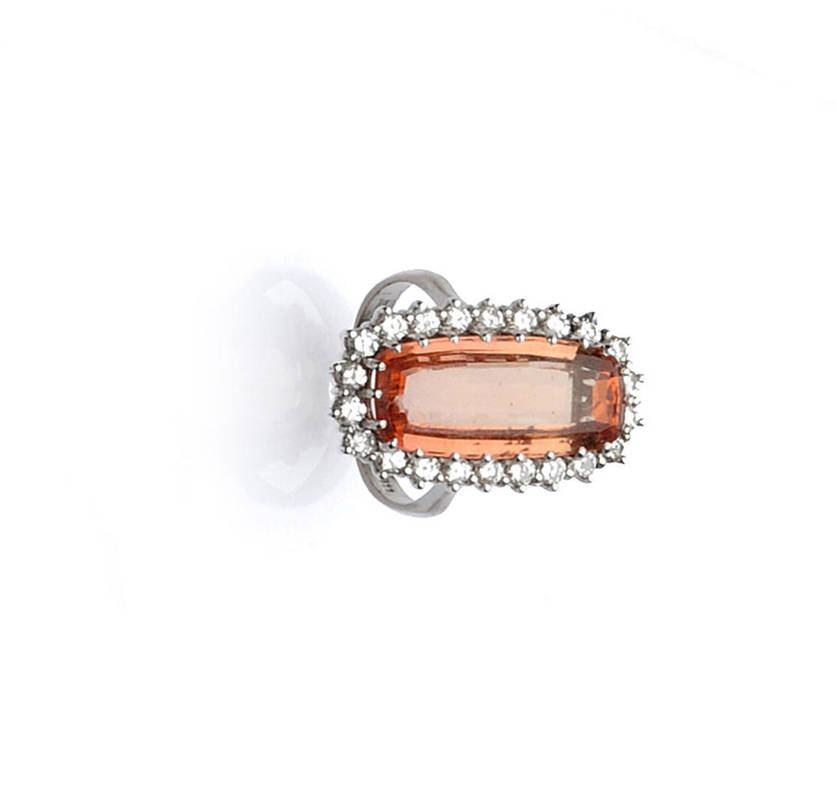 Lot 501 - An 14 Carat White Gold Topaz and Diamond Cluster Ring, the oval step cut orange coloured topaz...