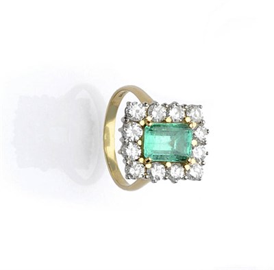 Lot 503 - An 18 Carat Gold Emerald and Diamond Cluster Ring, the emerald-cut emerald within a border of round