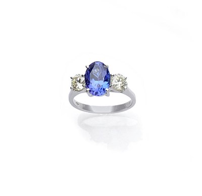 Lot 507 - An 18 Carat White Gold Tanzanite and Diamond Three Stone Ring, the oval cut tanzanite flanked...