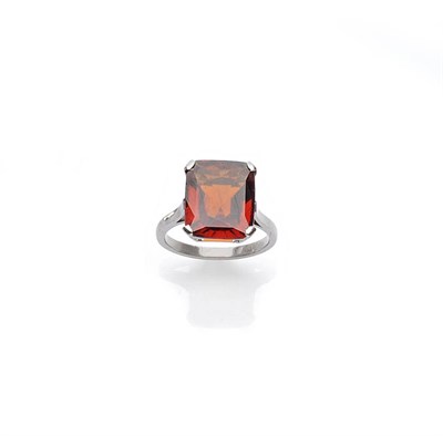 Lot 510 - A Hessonite Garnet Ring, the mixed cut hessonite garnet in a white four corner claw setting, to...