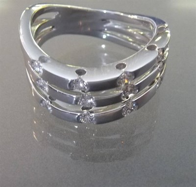 Lot 515 - An 18 Carat White Gold Diamond Ring, three polished white wavy bars are set with round...