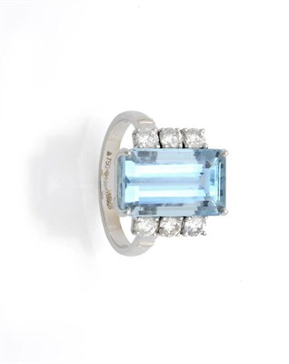 Lot 525 - An 18 Carat White Gold Aquamarine and Diamond Ring, the step cut aquamarine flanked by a row of...