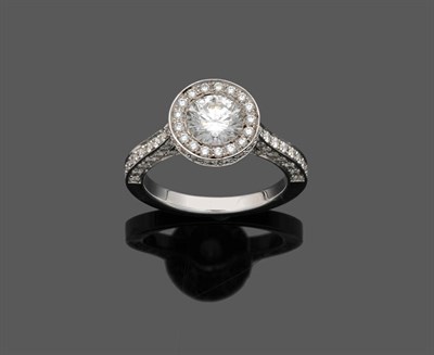 Lot 536 - A Diamond Ring, a round brilliant cut diamond sits within a frame of smaller round brillliant...