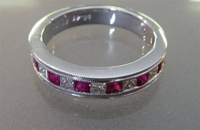 Lot 540 - A Ruby and Diamond Half Eternity Ring, the square cut rubies alternate with princess cut...