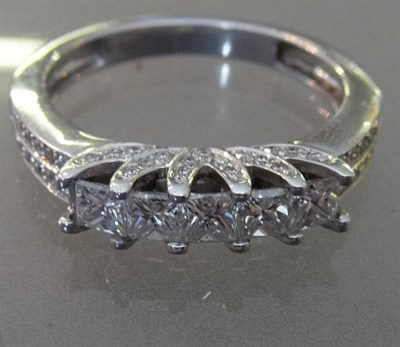 Lot 542 - An 18 Carat White Gold Diamond Five Stone Ring, the princess cut diamonds in claw settings on a...