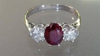 Lot 545 - A Ruby and Diamond Three Stone Ring, the oval mixed cut ruby flanked by a round brilliant cut...