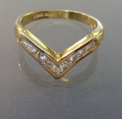 Lot 547 - An 18 Carat Gold Diamond Set Wishbone Ring, the round brilliant cut diamonds in a channel...