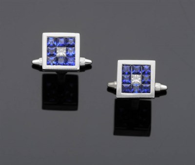 Lot 558 - A Pair of Diamond and Sapphire Cufflinks, a central princess cut diamond tension set in a border of