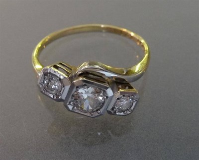 Lot 561 - A Diamond Three Stone Twist Ring, the round brilliant cut diamonds in white squared settings on...