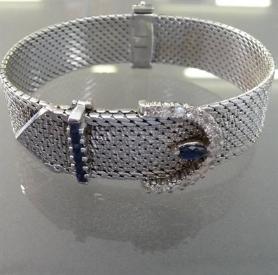 Lot 583 - An 18 Carat White Gold Diamond and Sapphire Set Buckle Bracelet, the textured broad bracelet...