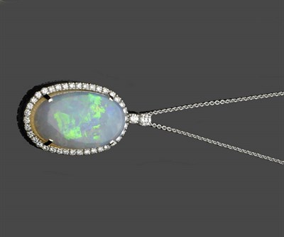 Lot 591 - An 18 Carat Gold Opal and Diamond Cluster Pendant on Chain, an oval cabochon opal within a...