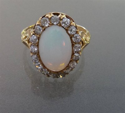 Lot 603 - An Opal and Diamond Cluster Ring, the oval cabochon opal within a border of old cut diamonds in...