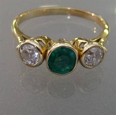 Lot 605 - An Emerald and Diamond Three Stone Ring, the oval step cut emerald flanked by a brilliant cut...