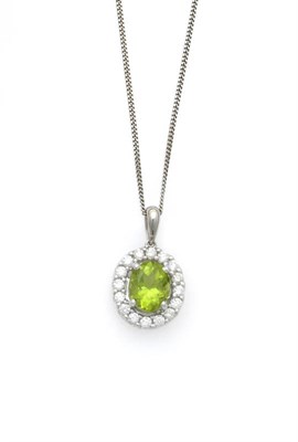 Lot 614 - A Peridot and Diamond Cluster Pendant on Chain, the oval cut peridot sits within a border of...