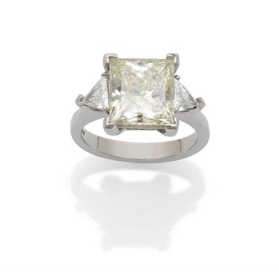 Lot 629 - A Platinum Princess Cut Diamond Ring with a Trillion Cut Diamond on Each Shoulder, the large...