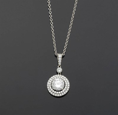 Lot 640 - A Diamond Pendant on Chain, the round brilliant cut diamond within a double border of smaller...