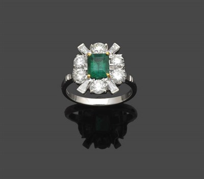 Lot 644 - An 18 Carat White Gold Emerald and Diamond Cluster Ring, the emerald-cut emerald in a four...