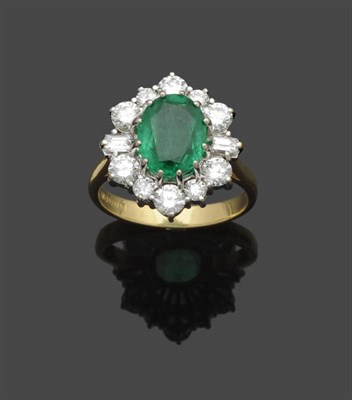 Lot 646 - An 18 Carat Gold Emerald and Diamond Cluster Ring, the oval mixed cut emerald sits within a...