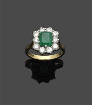 Lot 647 - An 18 Carat Gold Emerald and Diamond Cluster Ring, the emerald-cut emerald within a border of round