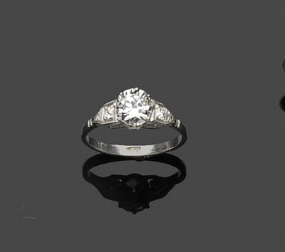 Lot 658 - An Art Deco Diamond Ring, the round brilliant cut diamond in a white claw setting to tiered diamond