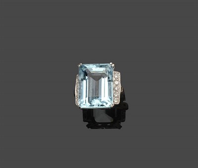 Lot 697 - An Aquamarine and Diamond Cluster Ring, the emerald-cut aquamarine within two lines of round...