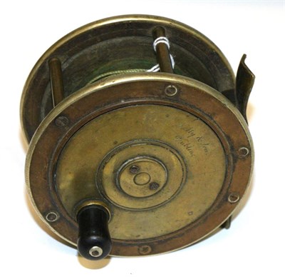 Lot 3093 - A 4inch Ebonite and Brass Salmon Reel by Kelly & Son, Dublin, with wooden handle, brass plate,...
