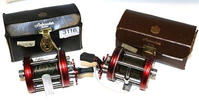 Lot 3116 - Two Abu Ambassadeur No.6000 Multiplying Reels, with metallic red finish, in leather cases