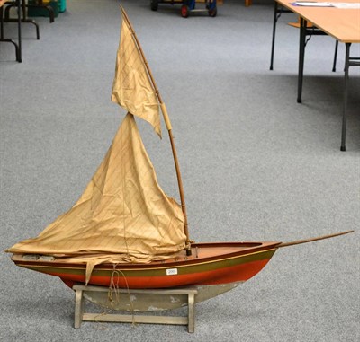 Lot 200 - A Wooden Pond Yacht, with red painted hull, lead keel, wooden mast, cloth sails, length of hull...