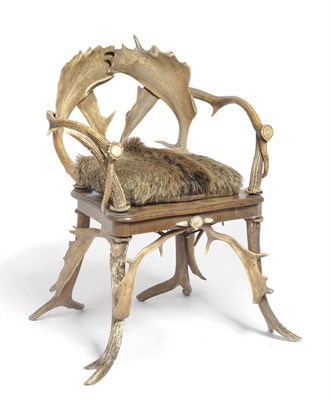 Lot 1095 - An Austro-German Antler Armchair, circa 1885, with original boar and acorn branch embossed...