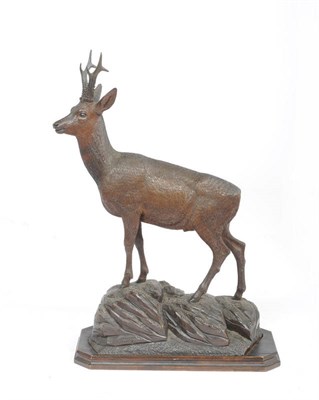 Lot 1163 - An Austrian Carved and Stained Linden Wood Roe Deer, circa 1890, standing on rocks, inset into...