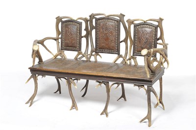 Lot 1184 - An Austro-German Antler Mounted Three-Seat Settee, circa 1885, with original embossed brown...