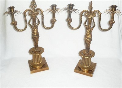 Lot 1196 - A Pair of French Gilt Metal Figural Candelabra in Empire Style, early 20th century, modelled as two