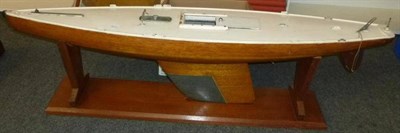 Lot 1077 - A Wooden Pond Yacht, with wooden hull, white painted deck, lead keel, mast and sail, on a...
