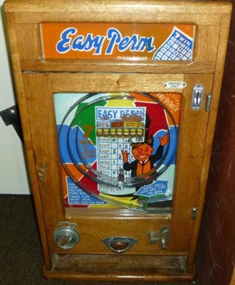 Lot 1142 - An Oak Cased Wall Mounted 'Easy Perm' Spin a Win Type Amusement Machine, with plastic covered...