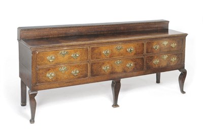 Lot 1393 - A Late 18th Century Oak Low Dresser, the staged back over six long drawers, fitted brass drop...