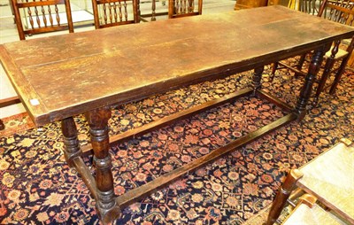 Lot 1395 - An Oak Refectory Dining Table, the rectangular cleated top on four turned baluster supports...