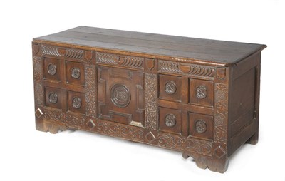 Lot 1400 - A Joined Oak Chest, the boarded lid above a carved frieze and central geometric moulded panel...