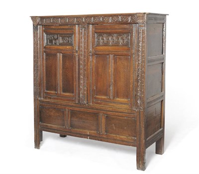 Lot 1405 - A Joined Oak Press Cupboard, the later top over a carved frieze and two fielded panel doors,...