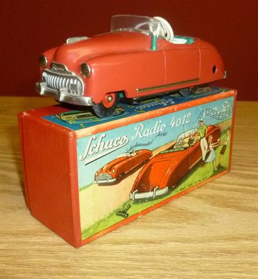 Lot 105 - A Boxed Schuco Clockwork Tinplate Radio 4012 Car, in red with green seat, Thorens movement,...